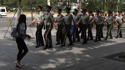 Des militaires surveillent les abords de la place de&nbsp;Tiananmen. (GREG BAKER / AFP)