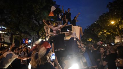 Sur les Champs-Elysées, plusieurs personnes n'ont pas hésité à grimper sur un camion frigorifique. (LUCAS BARIOULET / AFP)