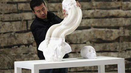 L'artiste chinois Li Hongbo &eacute;tire sa sculpture en papier &agrave; P&eacute;kin (Chine), le 20 janvier 2014. (JASON LEE / REUTERS)