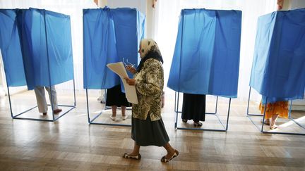 Une &eacute;lectrice passe devant des isoloirs lors de l'&eacute;lection pr&eacute;sidentielle, &agrave; Kiev (Ukraine), le 25 mai 2014. ( GLEB GARANICH / REUTERS)