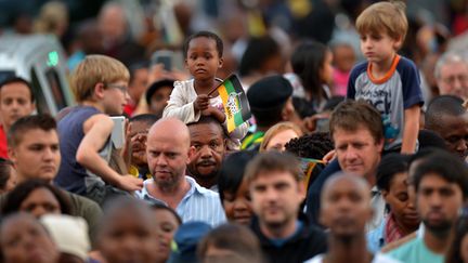 Un enfant agite un drapeau du parti ANC lors d'un rassemblement &agrave; Johannesbourg en Afrique du Sud, le 6 d&eacute;cembre 2013. (ALEXANDER JOE / AFP)