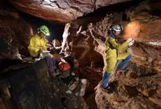 Les géologues entrent dans la grotte tailléedans le quartzite et prélèvent des échantillons de bactéries. (Géo/ Robbie SHONE)