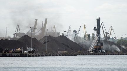 Un gros nuage de poussière de charbon s'élève au-dessus du port de Gdansk, après un déchargement, en Pologne, en juin 2023. (MATEUSZ SLODKOWSKI / AFP)