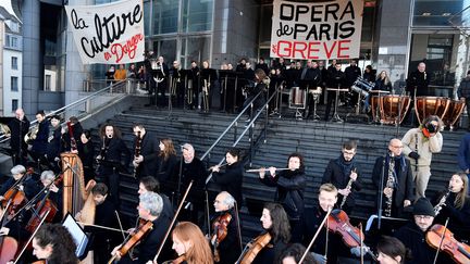 Des musiciens grévistes de l'Opéra Bastille jouent devant l'institution parisienne le 31 décembre 2019 en signe de protestation contre la réforme des retraites. (JULIEN MATTIA / ANADOLU AGENCY / AFP)