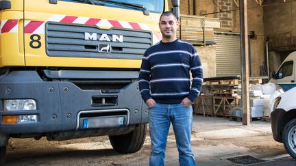 L'entrepreneur Julien Defives, 34 ans, à côté d'un des camions de sa société, à Pange (Moselle), le 1er novembre 2018. (ANNE BRIGAUDEAU / FRANCEINFO)