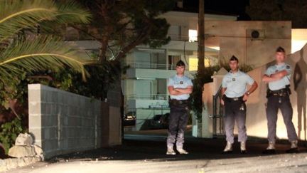 Des gendarmes gardent l'entrée de la résidence où ont été découverts les corps de 4 touristes, le 29 août à Algajola (AFP/PHOTO Pascal Pochard-Casabianca)