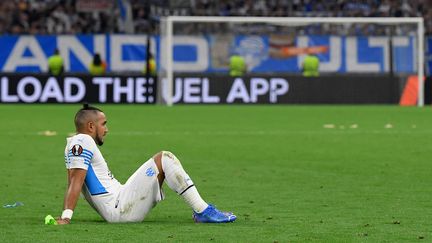 Dimitri Payet assis sur la pelouse du stade Vélodrome après le match entre l'OM et Galatasaray, le 30 septembre 2021. (NICOLAS TUCAT / AFP)