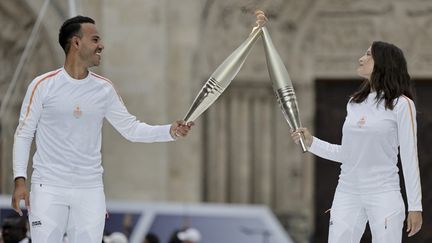 Belle image du journaliste Mohamed Bouhafsi et de l'actrice Laetitia Casta, devant la basilique Saint-Denis (Seine-Saint-Denis), le 26 juillet 2024. (STEPHANE DE SAKUTIN / AFP)