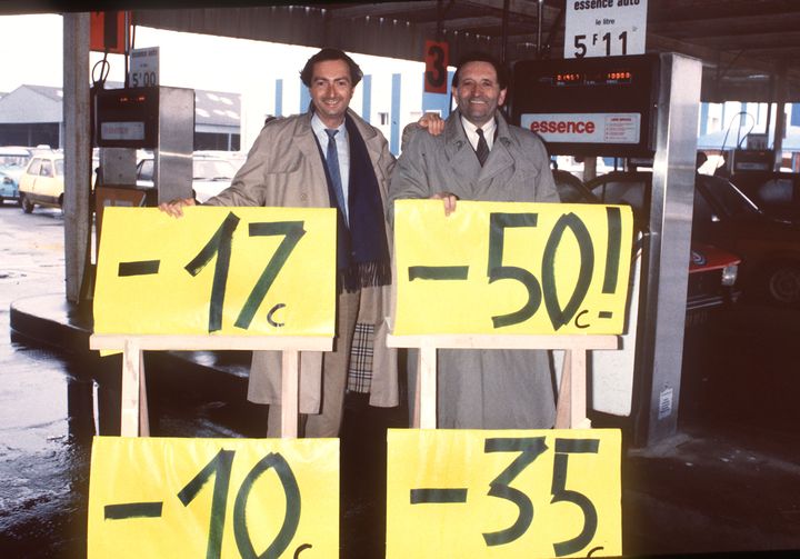 Edouard Leclerc (droite) et son fils Michel-Edouard font la publicit&eacute; de leurs promotions &agrave; Brest (Finist&egrave;re) devant une station d'essence, le 26 janvier 1985. (ANDRE DURAND / AFP)