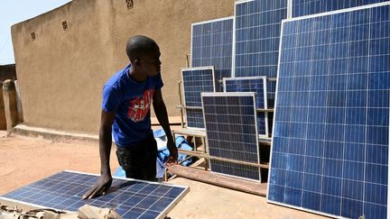 Un marchand de panneaux solaires dans une rue de Ouagadougou, la capitale du Burkina Faso. Le marché a explosé ces dernières années dans le pays.&nbsp;Le&nbsp;solaire compense&nbsp;la faiblesse du réseau électrique. (ISSOUF SANOGO / AFP)