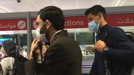 Le joueur de tennis serbe Novak Djokovic à sa descente d'avion à l'aéroport de Dubaï, le 17 janvier 2022, après avoir été expulsé d'Australie. (CAPTURE D'ECRAN AFPTV)