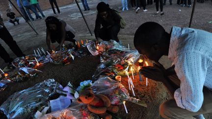 Des anonymes rendent hommage aux victimes du vol d'Air Alg&eacute;rie, &agrave; l'a&eacute;roport de Ouagadougou (Burkina Faso), le 26 juillet 2014. (SIA KAMBOU / AFP)