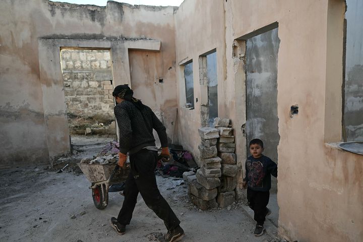 Des habitants réparent leur maison à Maarat al-Nouman, dans la province d'Idleb, au nord-ouest de la Syrie, le 14 décembre 2024. (OZAN KOSE / AFP)