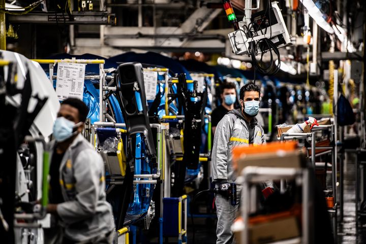 Des employés d'une usine Renault, à Flins-sur-Seine (Yvelines), travaillent avec un masque de protection, le 6 mai 2020. Les entreprises sont un des lieux où se sont déclarés le plus de clusters. (MARTIN BUREAU / AFP)