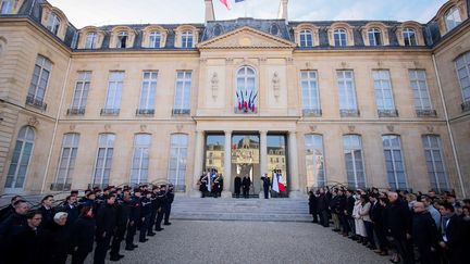 Emmanuel et Brigitte Macron observent une minute de silence en hommage aux victimes du cyclone Chido à Mayotte, depuis la cour d'honneur de l'Elysée, à Paris, le 23 décembre 2024.