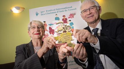 Martine et Jean-Marc Therouanne, les directeurs du Festival international des cinémas d'Asie (FICA), posent avec le Cyclo d'or, trophée décerné par le festival, dans l'est de la France, le 25 janvier 2024. (SEBASTIEN BOZON / AFP)