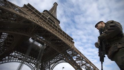 Un soldat patrouille au pied de la Tour Eiffel, le 14 janvier 2013. (JOEL SAGET / AFP)