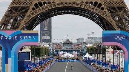 Le Belge Remco Evenepoel franchit seul la ligne d'arrivée près de la Tour Eiffel, remportant la course cycliste sur route masculine, le 3 août 2024. (ODD ANDERSEN / AFP)