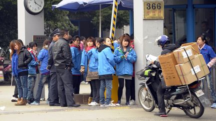 Des ouvriers &agrave; l'entr&eacute;e de l'usine d'&eacute;lectronique Hi-P International, le 2 d&eacute;cembre 2011 &agrave; Shanghai (Chine). (PETER PARKS / AFP)