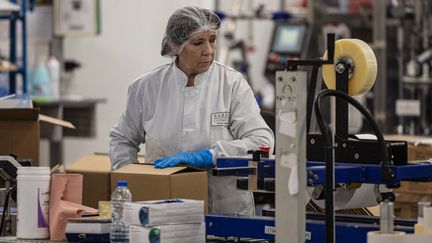 Une employée sur une chaîne de production de l'usine Sarbec Cosmetics à Neuville-en-Ferrain (Nord), le 9 février 2023. (SAMEER AL-DOUMY / AFP)