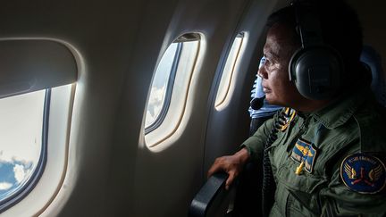 Un membre des &eacute;quipes de recherches indon&eacute;siennes scrutant la mer de Java au dessus de laquelle a disparu le vol QZ8501 de la compagnie malaisienne AirAsia. (JUNI KRISWANTO / AFP)