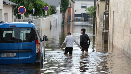 Des personnes marchent à Châteaubriant (Loire-Atlantique) pendant les inondations, le 12 juin 2018. (RONAN HOUSSIN / CROWDSPARK / AFP)