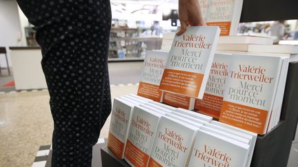 Une personne prend un exemplaire du livre de Val&eacute;rie Trierweiler, le 4 septembre 2014, dans une librairie, &agrave; Paris. (PATRICK KOVARIK / AFP)