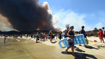 Les vacanciers quittent la plage alors qu'un feu ravage la forêt de Bormes-les-Mimosas en Provence Alpes Côte d'Azur, le 26 juillet 2017.&nbsp; (ANNE-CHRISTINE POUJOULAT / AFP)