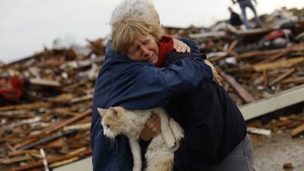 Des habitants de Moore (Oklahoma, Etats-Unis), dans les d&eacute;combres de leurs maisons d&eacute;truites par une tornade, le 21 mai 2013. (JOSHUA LOTT / AFP)