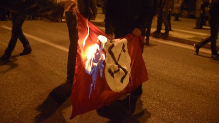 En Gr&egrave;ce, &agrave; Ath&egrave;nes, des manifestants br&ucirc;lent un drapeau nazi, le 17 novembre 2013. (CITIZENSIDE / CHRISTOS STAMOS / AFP)