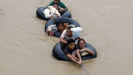 Des victimes d'inondations sont tir&eacute;es sur des chambres &agrave; air afin d'&ecirc;tre &eacute;vacu&eacute;es apr&egrave;s le passage du cyclone tropical Agaton &agrave; Butuan (Philippines), le 20 janvier 2014. (ERIK DE CASTRO / REUTERS)