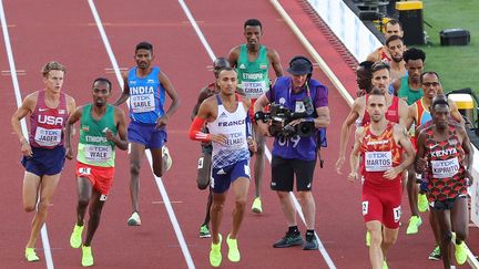 Un caméraman entouré des 15 participants de la finale du 3 000 m steeple aux mondiaux d'athlétisme d'Eugene, le 18 juillet 2022. (CARMEN MANDATO / GETTY IMAGES NORTH AMERICA / AFP)