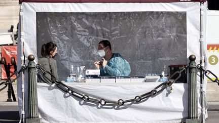 Un soignant prépare un test de dépistage du coronavirus antigénique avant de tester une patiente, à Paris, le 31 mars 2021. (THOMAS COEX / AFP)