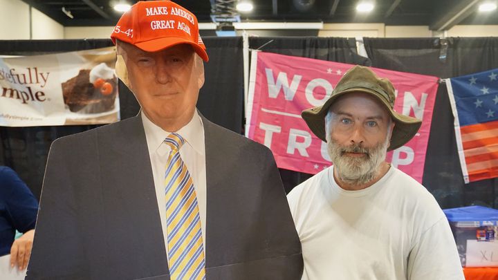 David, un électeur républicain, pose à côté d'une photo de Donald Trump. (MARIE-VIOLETTE BERNARD / FRANCEINFO)