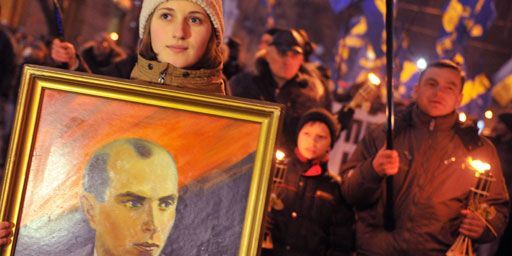 Kiev, le 1er Janvier 2013: une jeune Ukrainienne brandit un portrait de Stepan Bandera, qui fut l'un des dirigeants de l'Organisation des nationalistes ukrainiens dans l'ouest du pays, lors d'une marche célébrant le 104e anniversaire de sa naissance. (AFP PHOTO/GENYA SAVILOV)