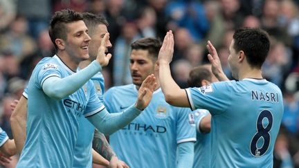 Le joueur de Manchester City Steven Jovetic congratule son co&eacute;quipier fran&ccedil;ais&nbsp;Samir Nasri, le 5 avril 2014, &agrave; Manchester (Royaume-Uni). (LINDSEY PARNABY / AFP)