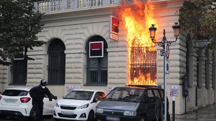 Un homme s'enfuit après avoir lancé un cocktail Molotov sur une banque, à Bastia (Haute-Corse), samedi 15 octobre 2016.&nbsp; (PASCAL POCHARD-CASABIANCA / AFP)