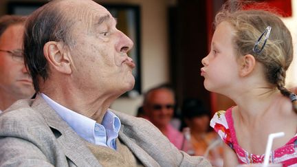 Concours de grimaces / bisous entre l'ancien pr&eacute;sident de la R&eacute;publique Jacques Chirac et une petite fille en terrasse &agrave; Saint-Tropez, le 14 ao&ucirc;t 2011. (SEBASTIEN NOGIER / AFP)