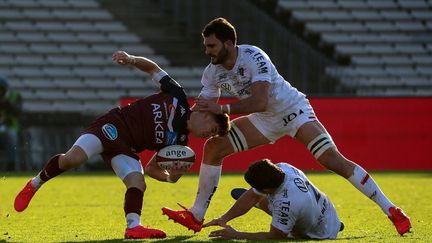 Matthieu Jalibert (UBB), auteur de 21 points lors de la rencontre, est taclé par le Toulonnais Charles Ollivon. (ROMAIN PERROCHEAU / AFP)