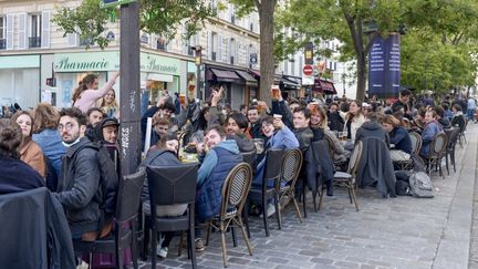 Des Parisiens profitent de la réouverture des terrasses des bars et restaurants, à Paris, le 19 mai 2021. (REMI DECOSTER / HANS LUCAS / AFP)