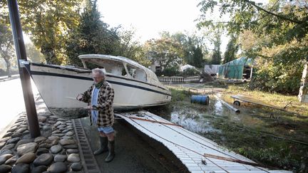 Un habitant de Biot montre avec ses mains, dimanche 4 octobre, la hauteur &agrave; laquelle est mont&eacute;e l'eau, la veille. ( ERIC GAILLARD / REUTERS)