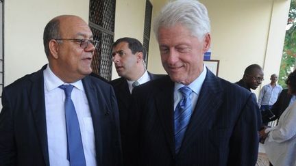 L'ancien président américain Bill Clinton (D) et Gregory Mevs (G), le 17 septembre 2012, pendant une visite à L'Université Notre Dame de Port-au-Prince (Haiti). (THONY BELIZAIRE / AFP)