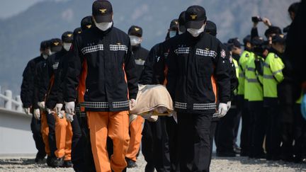 Les secours sud-cor&eacute;ens avec les corps retrouv&eacute;s dans le ferry naufrag&eacute;, &agrave; Jindo (Cor&eacute;e du Sud), le 20 avril 2014. (ED JONES / AFP)