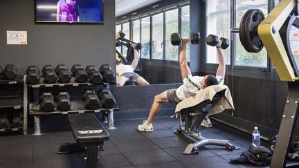 Un jeune homme s'entraîne dans une salle de musculation (photo d'illustration). (JEAN-FRANCOIS FORT / AFP)