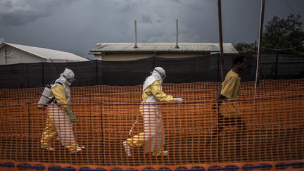 Des membres du personnel soignant d'un centre de Médecins sans frontières accompagnent un patient suspecté d'être porteur du virus Ebola, à Bunia, dans le nord-est de la République démocratique du Congo, le 7 novembre 2018. (JOHN WESSELS / AFP)