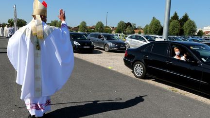 L'évêque de Châlons-en-Champagne (Marne), François Touvet, salue une fidèle, le 17 mai 2020. (FRANCOIS NASCIMBENI / AFP)