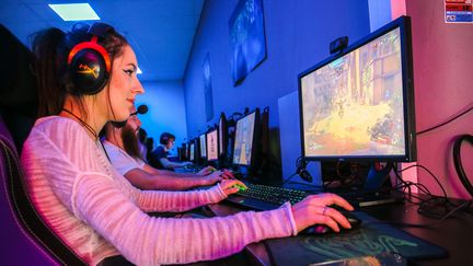 Une jeune femme joue&nbsp;à une partie du jeu video en ligne Overwatch et en streaming video chat dans le centre esport de Valence, le 21&nbsp;août 2019.&nbsp; (NICOLAS GUYONNET / HANS LUCAS / AFP)