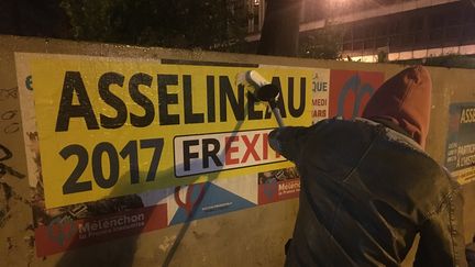 Un colleur d'affiches de François Asselineau, le 29 mars 2017 à Paris. (THOMAS BAIETTO / FRANCEINFO)