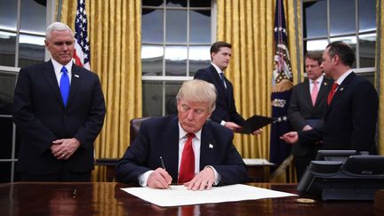 Donald Trump dans le bureau ovale de la Maison Blanche, après son investiture comme président des Etats-Unis, le 20 janvier 2017. (JIM WATSON / AFP)