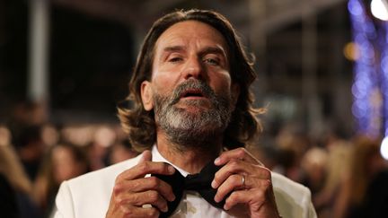 Ajustements de dernière minute pour l'écrivain&nbsp;Frédéric Beigbeder avant d'aller assister à la projection de "Novembre" de Cédric Jimenez.&nbsp; (VALERY HACHE / AFP)